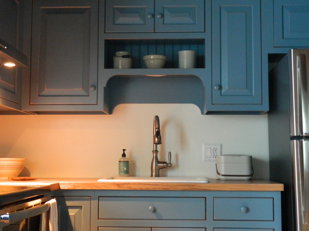 Photo of a small rustic l-shaped kitchen/diner in Philadelphia with blue cabinets and wood worktops.