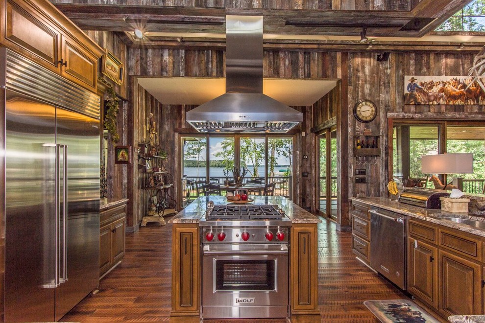 Photo of a rustic open plan kitchen in Atlanta with a submerged sink, raised-panel cabinets, dark wood cabinets, stainless steel appliances, dark hardwood flooring, an island, brown floors and brown worktops.