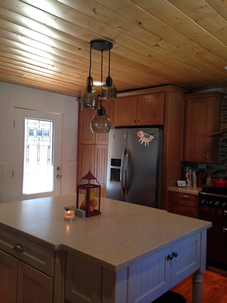 Exempel på ett mellanstort rustikt kök, med en rustik diskho, luckor med profilerade fronter, skåp i ljust trä, bänkskiva i koppar, beige stänkskydd, stänkskydd i glaskakel, rostfria vitvaror, mellanmörkt trägolv och en köksö