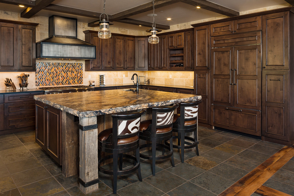 Foto på ett stort rustikt flerfärgad kök, med en undermonterad diskho, granitbänkskiva, integrerade vitvaror, skiffergolv, en köksö, luckor med infälld panel, skåp i mörkt trä, flerfärgad stänkskydd och brunt golv