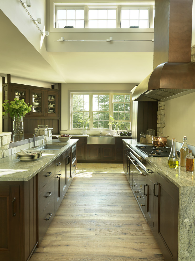 Trendy kitchen photo in St Louis with a farmhouse sink, granite countertops, recessed-panel cabinets and dark wood cabinets