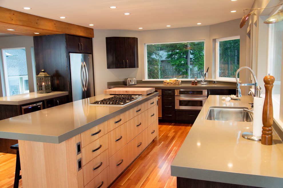 Example of a trendy kitchen design in Vancouver with an undermount sink, flat-panel cabinets, stainless steel appliances and light wood cabinets