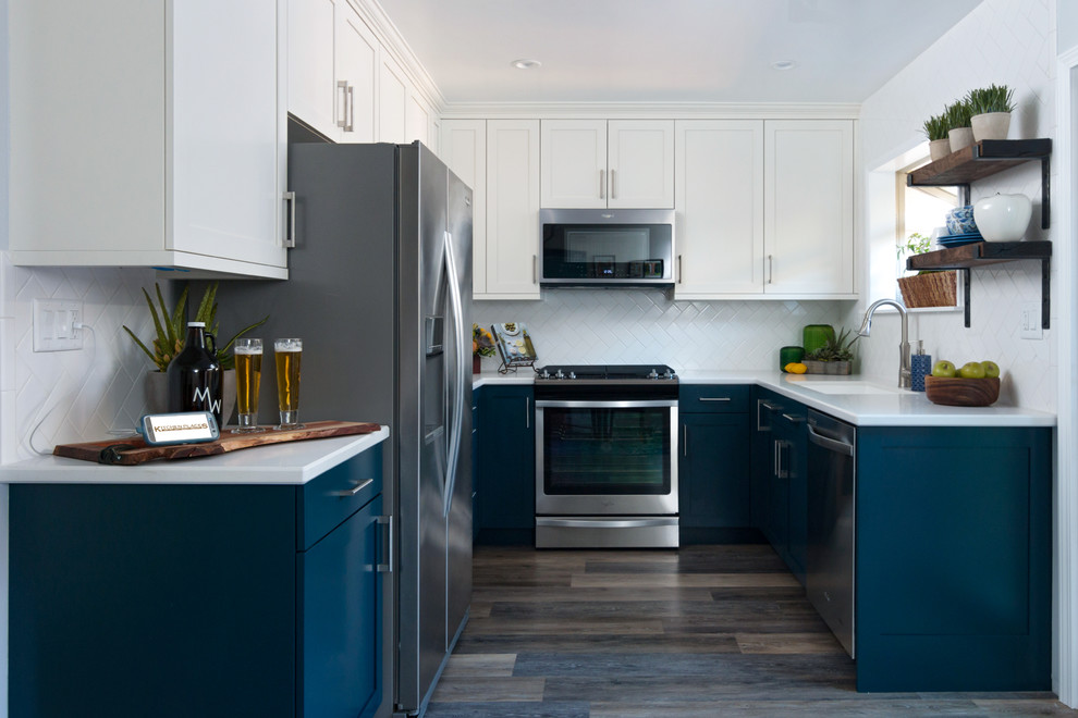 Exempel på ett litet modernt vit vitt kök, med luckor med infälld panel, blå skåp, vitt stänkskydd, stänkskydd i keramik, rostfria vitvaror, en dubbel diskho, bänkskiva i kvarts, laminatgolv och brunt golv