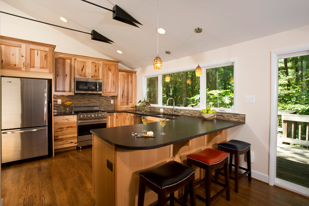 This is an example of a rustic u-shaped open plan kitchen in DC Metro with a submerged sink, raised-panel cabinets, medium wood cabinets, engineered stone countertops, multi-coloured splashback, matchstick tiled splashback, stainless steel appliances, dark hardwood flooring and a breakfast bar.