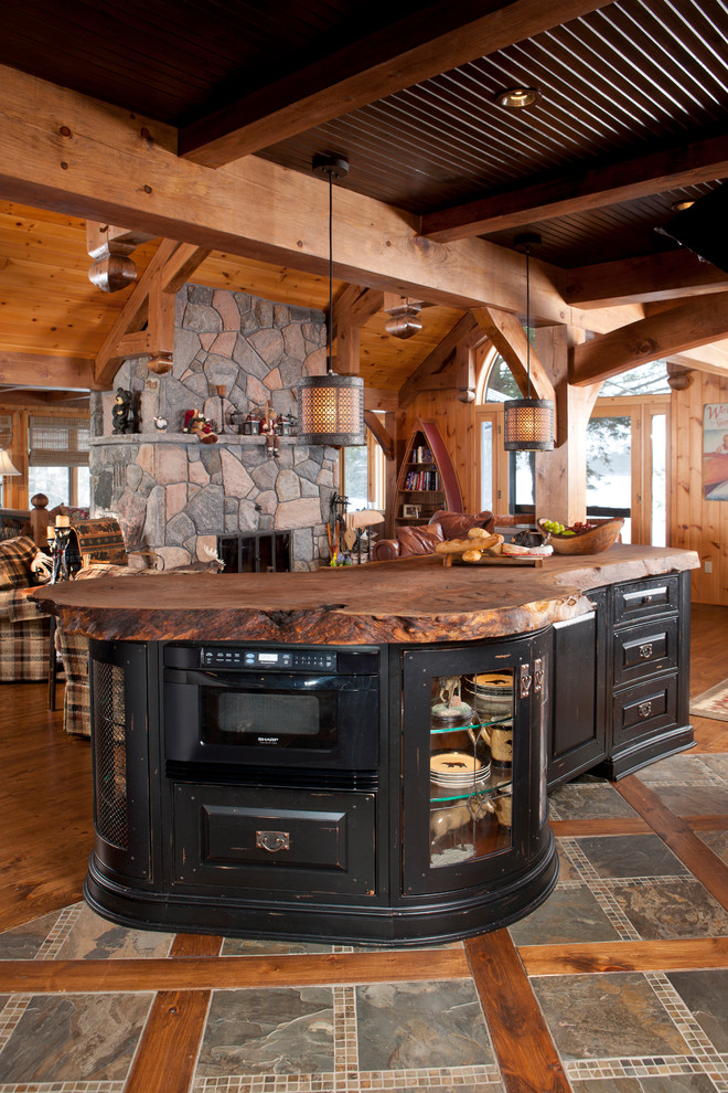 Exempel på ett mellanstort rustikt kök, med luckor med upphöjd panel, skåp i slitet trä, granitbänkskiva, integrerade vitvaror, mellanmörkt trägolv, en köksö och brunt golv
