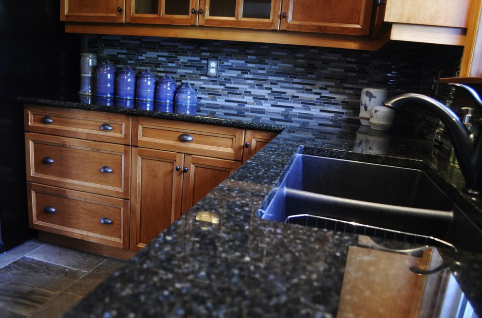 Foto di una cucina a L rustica di medie dimensioni con lavello sottopiano, ante in legno scuro, top in granito, paraspruzzi blu, elettrodomestici in acciaio inossidabile e nessuna isola