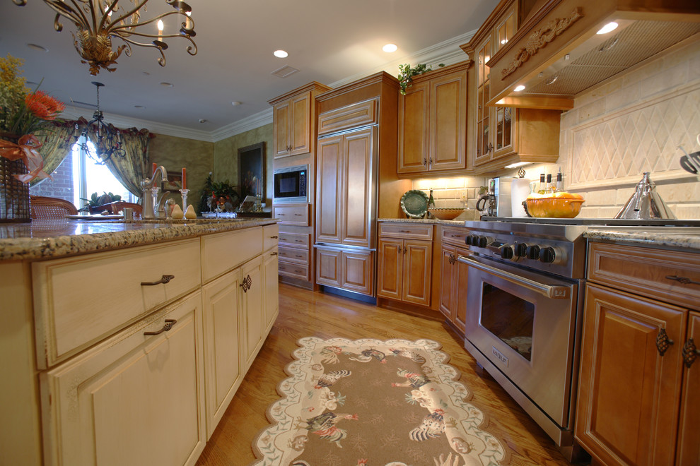 Photo of a large classic open plan kitchen in Cincinnati with a double-bowl sink, raised-panel cabinets, medium wood cabinets, granite worktops, beige splashback, stainless steel appliances, medium hardwood flooring and an island.