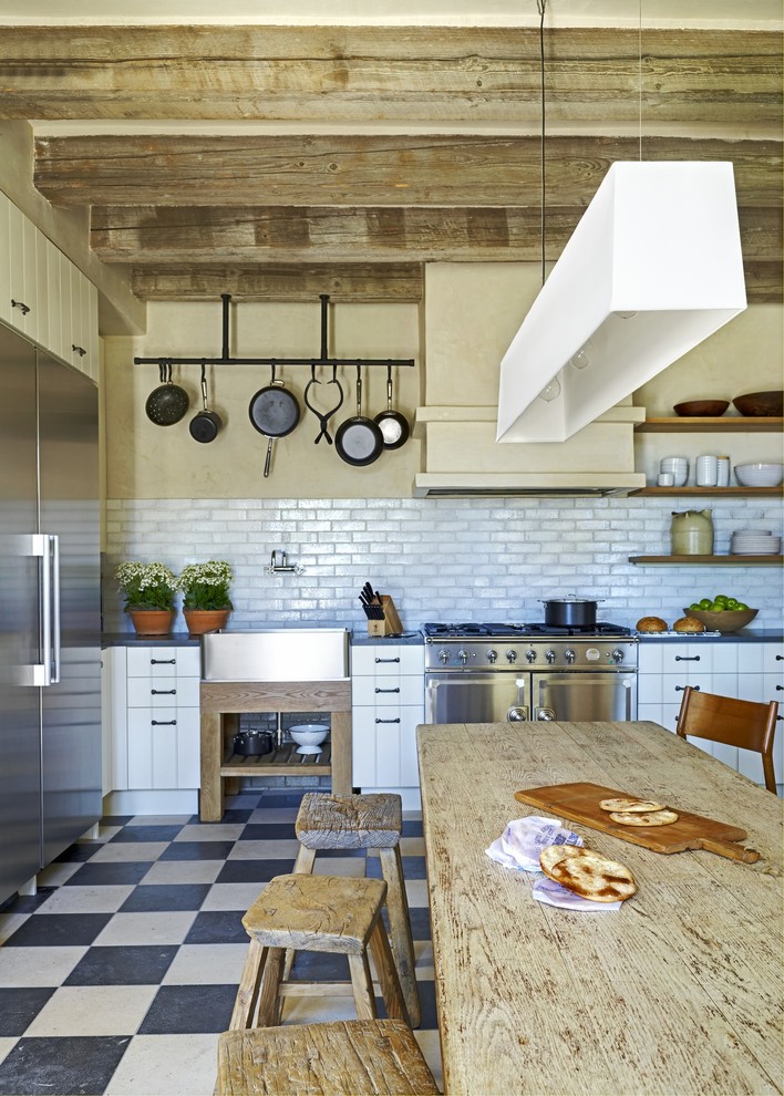 Photo of a mediterranean kitchen in Phoenix with a belfast sink and stainless steel appliances.