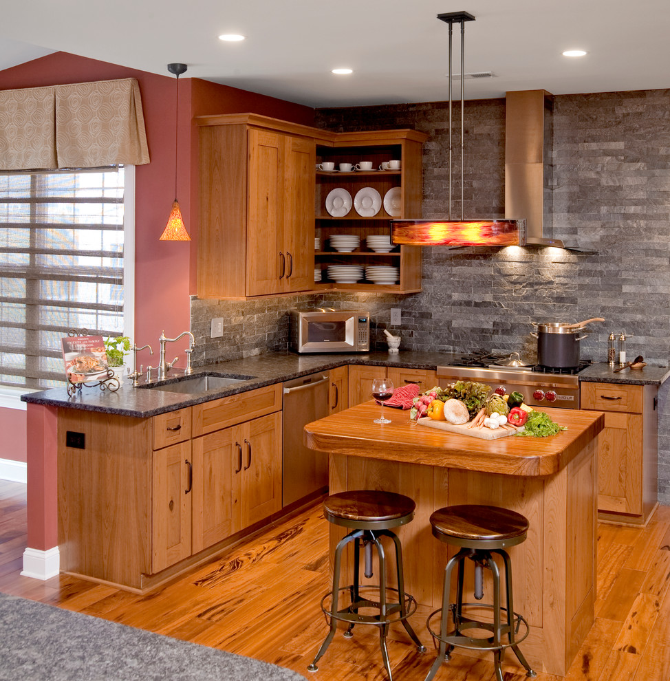 Exemple d'une cuisine tendance en bois brun avec un électroménager en acier inoxydable, un plan de travail en granite, un évier 1 bac, un placard sans porte, une crédence grise et une crédence en ardoise.