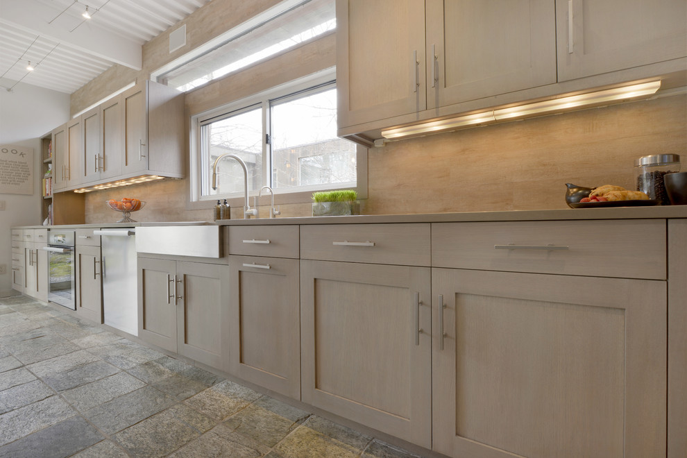 Inspiration for a large coastal l-shaped kitchen/diner in New York with a belfast sink, shaker cabinets, light wood cabinets, engineered stone countertops, beige splashback, porcelain splashback, stainless steel appliances, an island and multi-coloured floors.