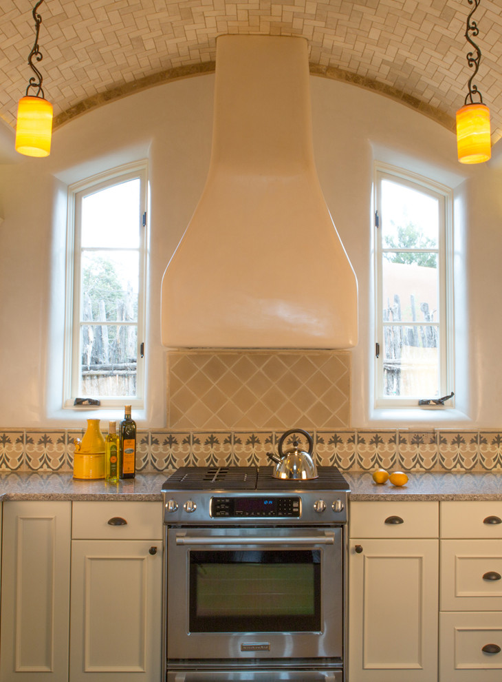 Bild på ett stort medelhavsstil kök, med en enkel diskho, släta luckor, svarta skåp, granitbänkskiva, flerfärgad stänkskydd, stänkskydd i mosaik, rostfria vitvaror, klinkergolv i keramik och en halv köksö