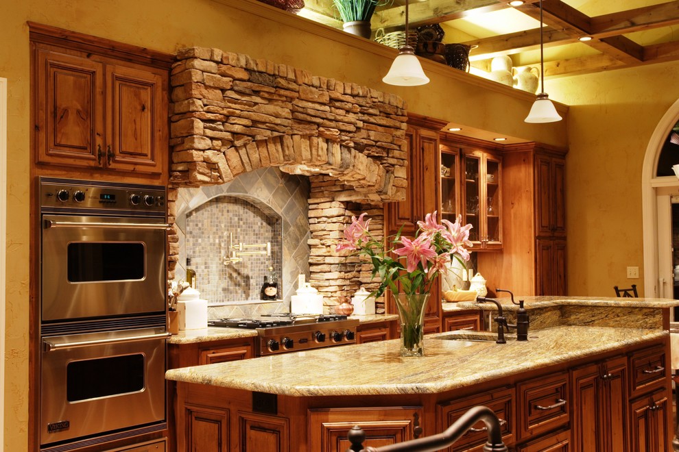 Example of a mountain style eat-in kitchen design in St Louis with an undermount sink, raised-panel cabinets, medium tone wood cabinets, granite countertops and stainless steel appliances