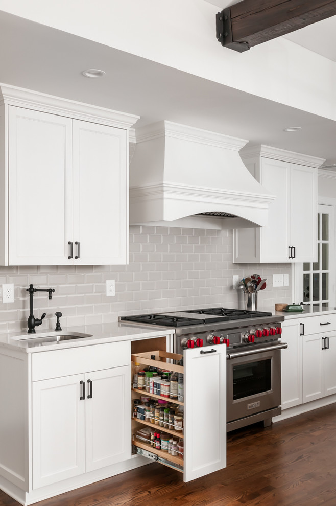 Inspiration for a large traditional kitchen in Atlanta with a single-bowl sink, shaker cabinets, white cabinets, engineered stone countertops, grey splashback, ceramic splashback, stainless steel appliances, dark hardwood flooring, an island and white worktops.