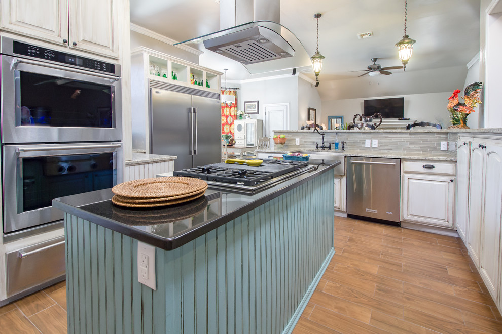 Foto på ett stort lantligt kök, med en rustik diskho, luckor med upphöjd panel, vita skåp, granitbänkskiva, grått stänkskydd, stänkskydd i stickkakel, rostfria vitvaror, mellanmörkt trägolv, en köksö och brunt golv