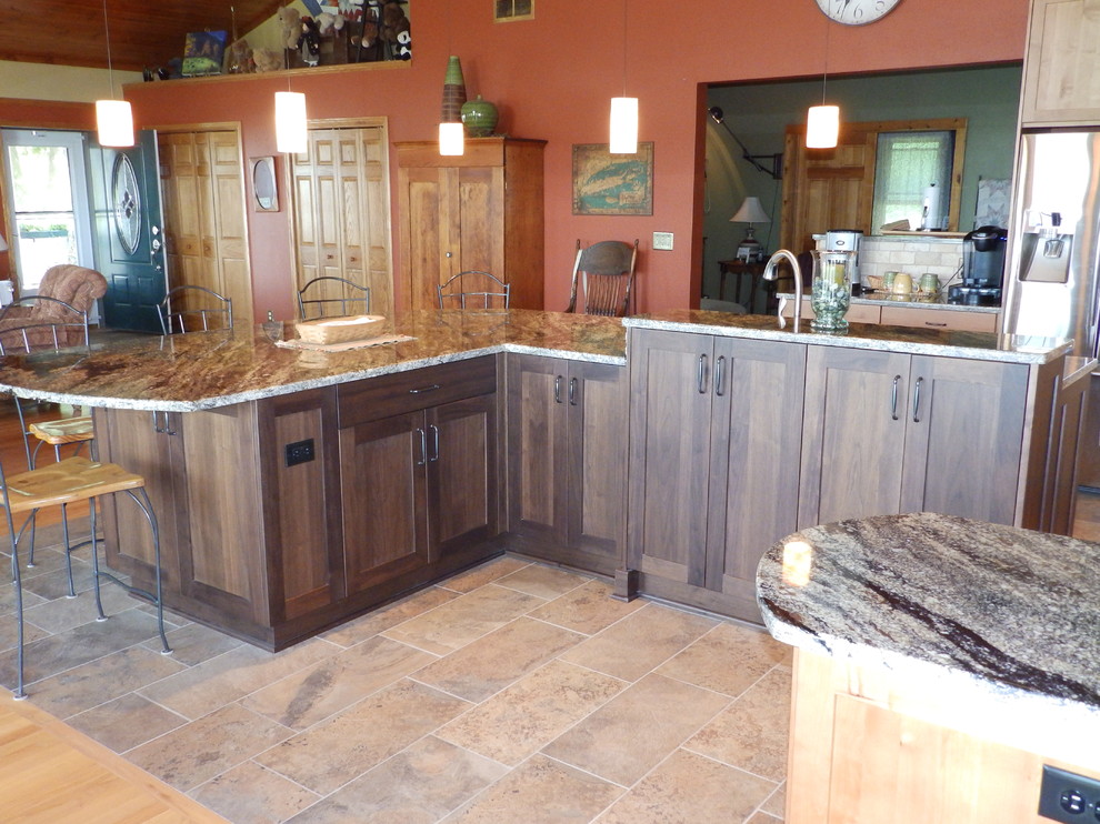 Cette image montre une grande cuisine ouverte rustique en L et bois brun avec un placard à porte shaker, un plan de travail en granite, une crédence en mosaïque et un électroménager en acier inoxydable.