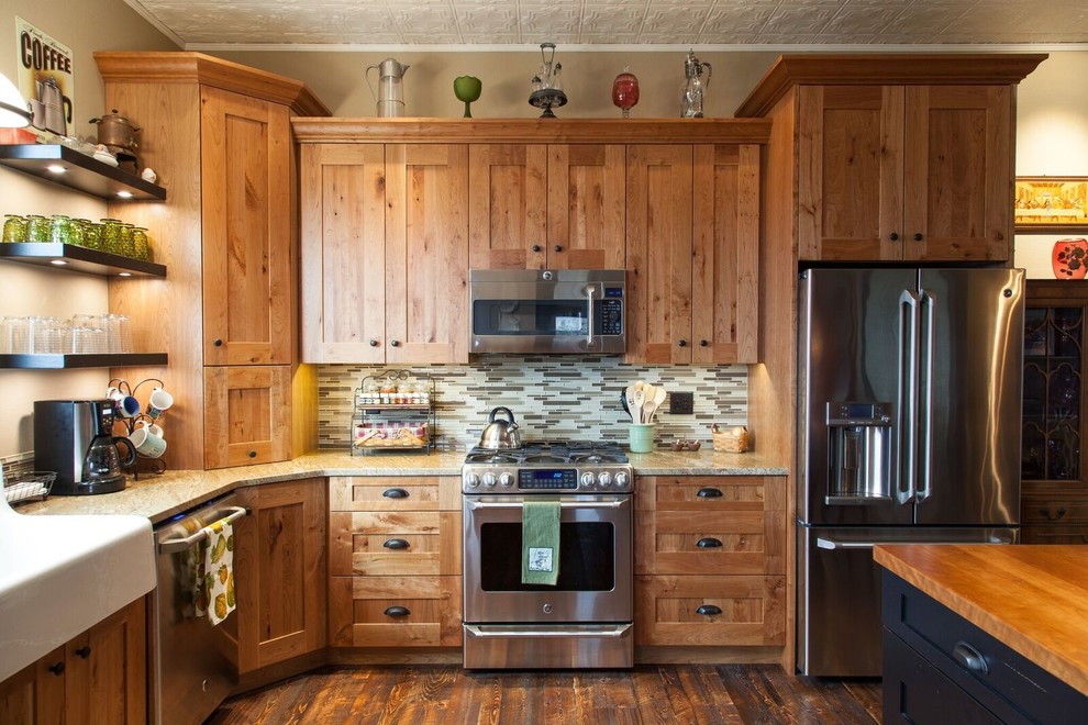 Foto på ett mellanstort amerikanskt kök, med en rustik diskho, skåp i shakerstil, skåp i mellenmörkt trä, granitbänkskiva, beige stänkskydd, stänkskydd i metallkakel, rostfria vitvaror och mörkt trägolv