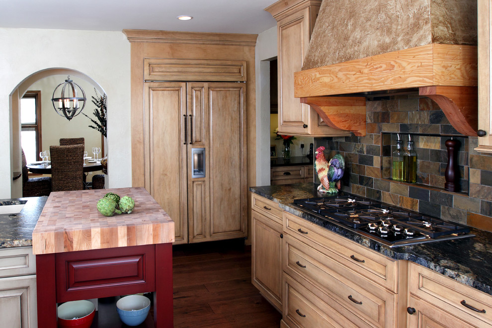 Diseño de cocina rural con encimera de madera, salpicadero multicolor, armarios con paneles con relieve, puertas de armario de madera clara, electrodomésticos con paneles y salpicadero de pizarra