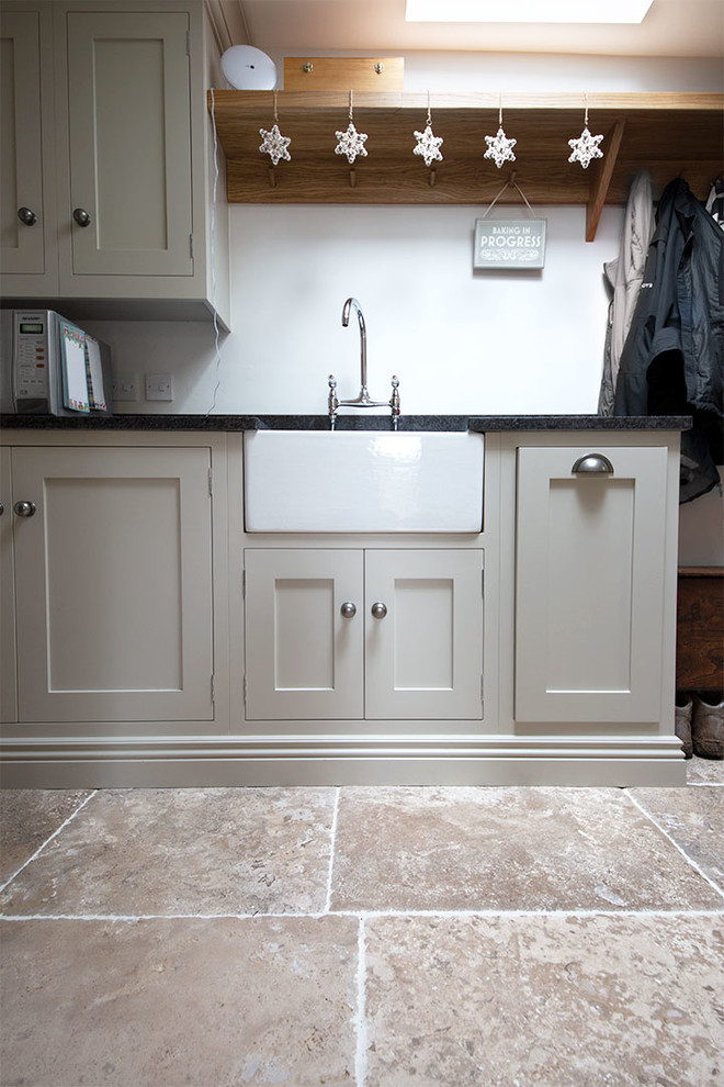 Foto på ett mellanstort lantligt kök, med kalkstensgolv, en köksö och beiget golv
