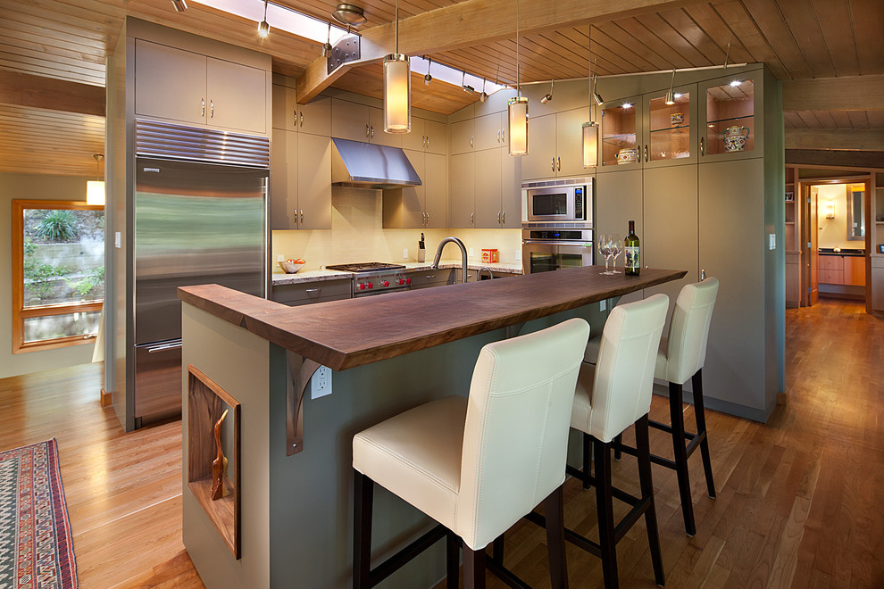 Свежая идея для дизайна: угловая кухня среднего размера в современном стиле с обеденным столом, островом, одинарной мойкой, плоскими фасадами, зелеными фасадами и техникой из нержавеющей стали - отличное фото интерьера