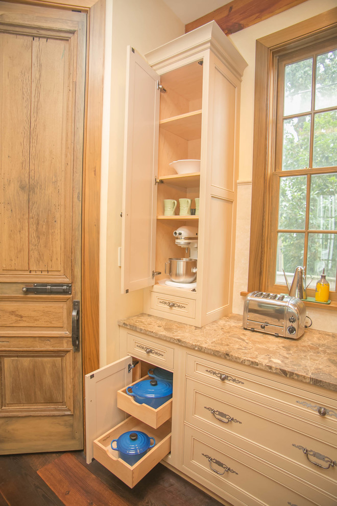 Inredning av ett rustikt stort l-kök, med en enkel diskho, luckor med infälld panel, skåp i slitet trä, marmorbänkskiva, rostfria vitvaror, mörkt trägolv och en köksö