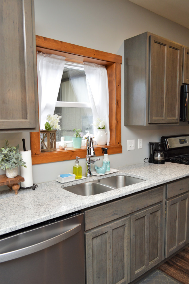 Idéer för ett mellanstort rustikt grå kök, med en undermonterad diskho, luckor med infälld panel, grå skåp, bänkskiva i kvartsit, rostfria vitvaror, laminatgolv, en köksö och brunt golv