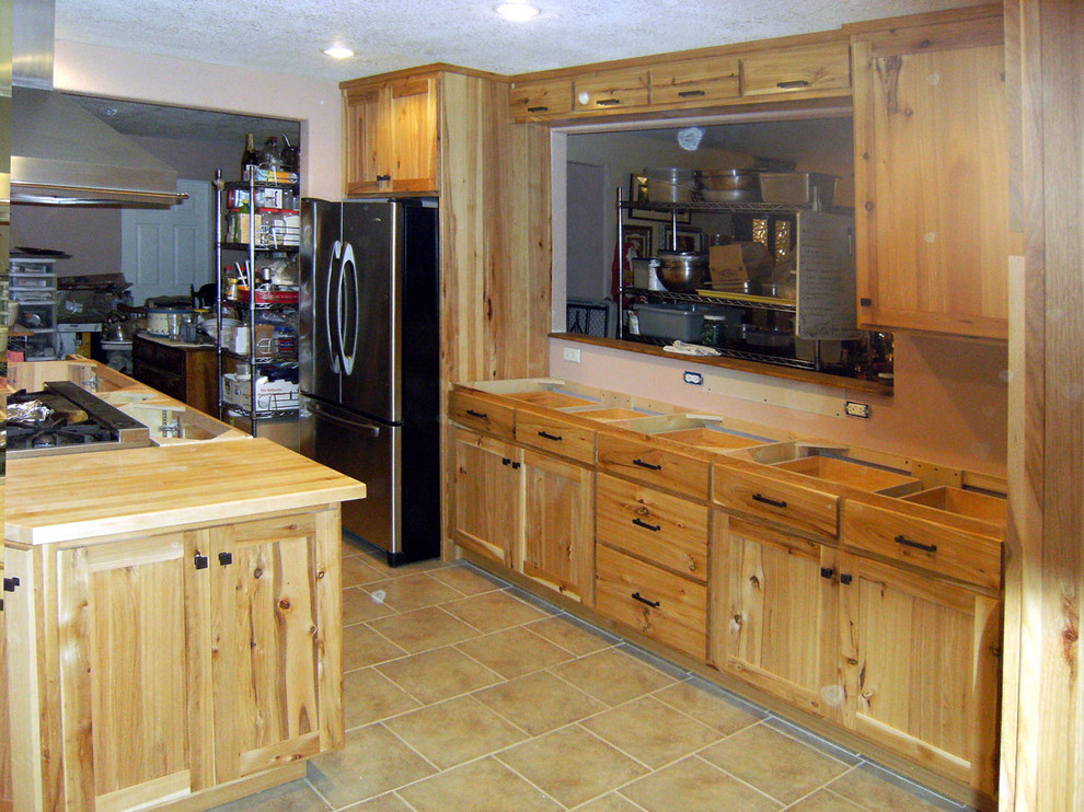Cette photo montre une cuisine avec un placard à porte shaker, un électroménager en acier inoxydable et îlot.