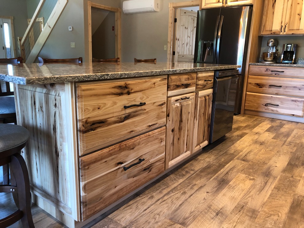 Foto de cocina de estilo americano con armarios con paneles con relieve, puertas de armario de madera clara, encimera de cuarcita y una isla