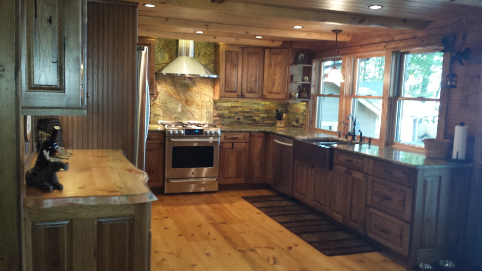 Urige Küche mit hellbraunen Holzschränken, Granit-Arbeitsplatte und weißen Elektrogeräten in Sonstige