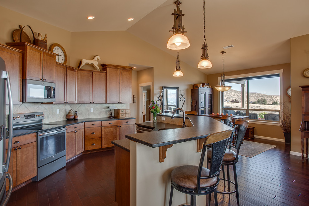 Mid-sized mountain style galley dark wood floor and brown floor open concept kitchen photo in Seattle with an undermount sink, shaker cabinets, medium tone wood cabinets, laminate countertops, beige backsplash, ceramic backsplash, stainless steel appliances and an island