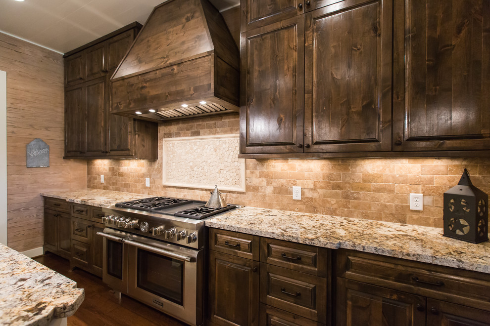 Foto på ett stort rustikt kök, med en rustik diskho, luckor med upphöjd panel, skåp i mörkt trä, granitbänkskiva, beige stänkskydd, stänkskydd i keramik, rostfria vitvaror, mellanmörkt trägolv, en köksö och brunt golv