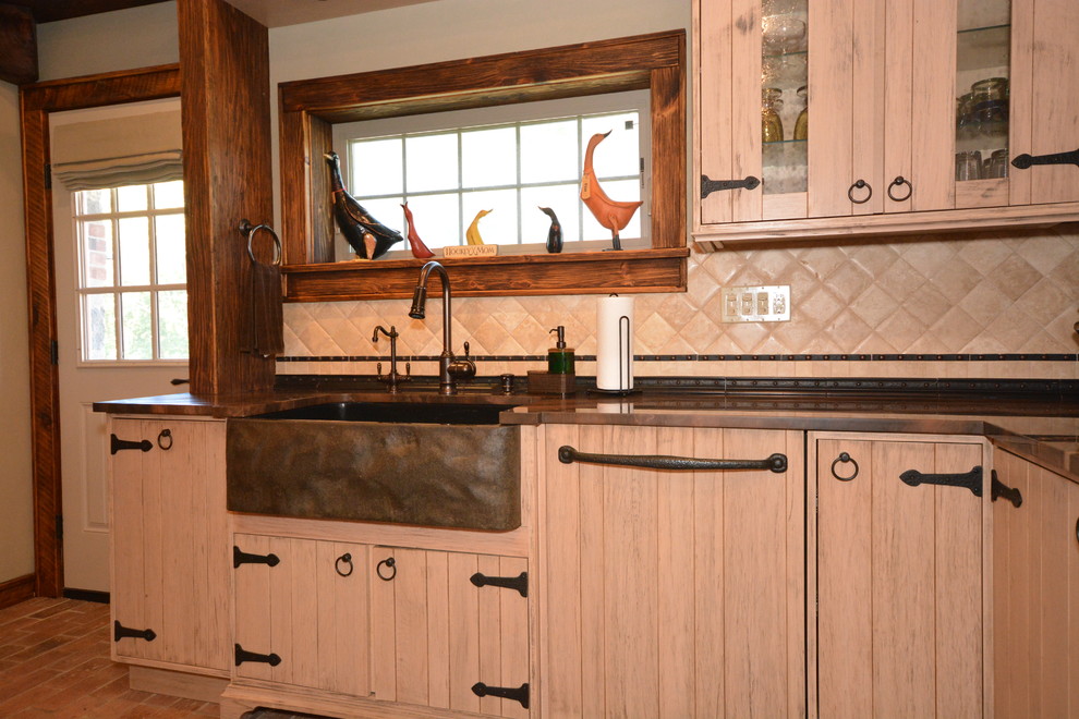 Immagine di una grande cucina abitabile rustica con lavello stile country, ante beige, top in quarzite, paraspruzzi in pietra calcarea e pavimento in mattoni