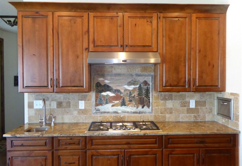 Idéer för ett mellanstort rustikt flerfärgad linjärt kök och matrum, med en undermonterad diskho, luckor med upphöjd panel, bruna skåp, granitbänkskiva, beige stänkskydd, stänkskydd i travertin, rostfria vitvaror, mellanmörkt trägolv, en köksö och brunt golv