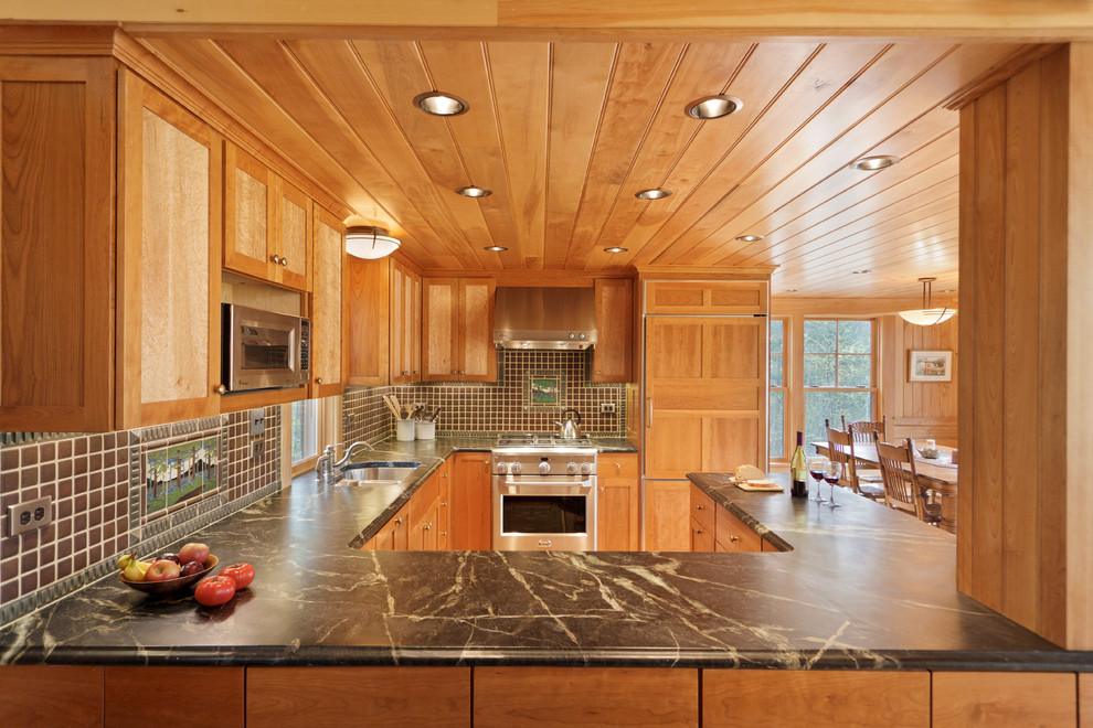 ワシントンD.C.にあるトラディショナルスタイルのおしゃれなキッチン (アンダーカウンターシンク、落し込みパネル扉のキャビネット、中間色木目調キャビネット、茶色いキッチンパネル、シルバーの調理設備) の写真