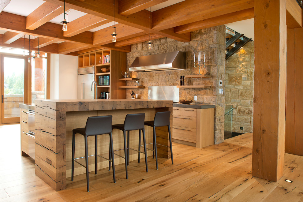 Immagine di un cucina con isola centrale stile rurale con ante lisce, ante in legno scuro, top in legno, elettrodomestici in acciaio inossidabile e pavimento in legno massello medio