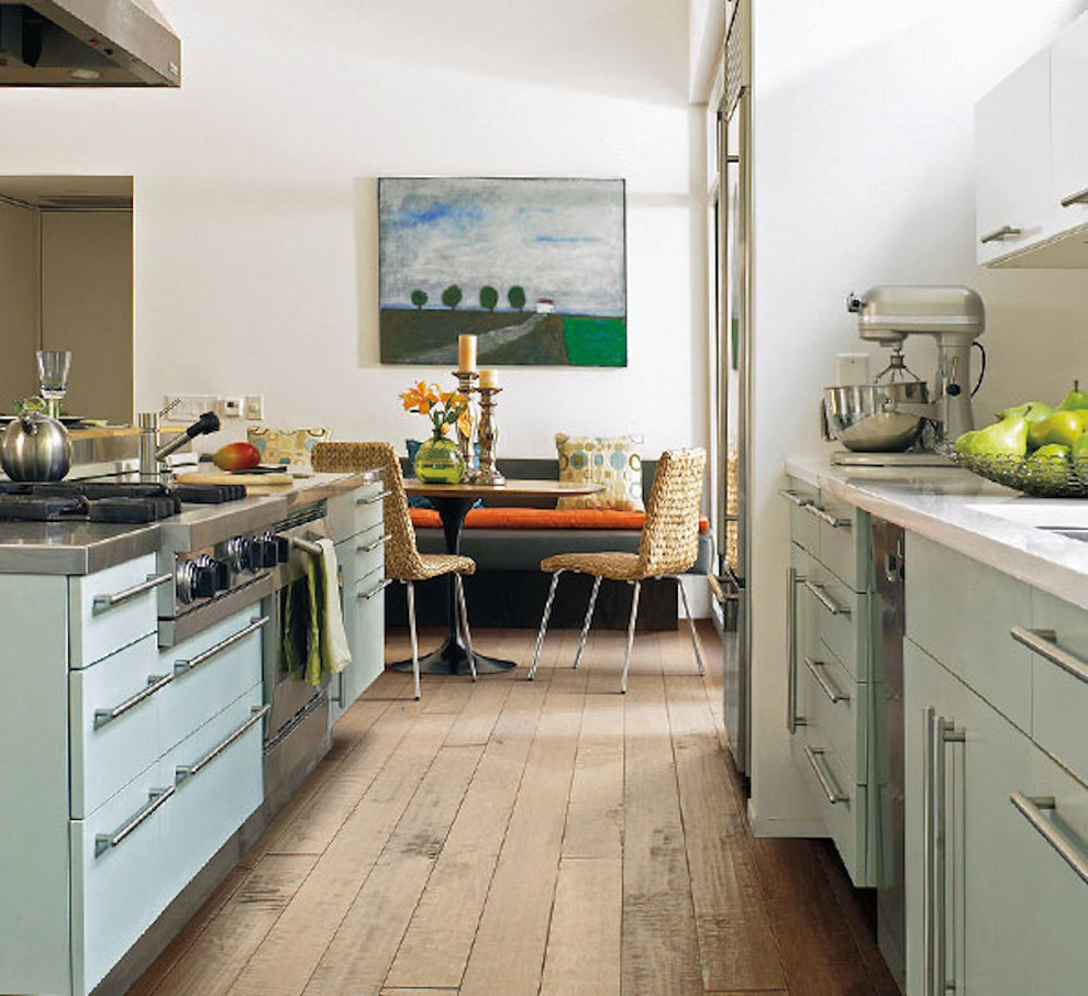 Exempel på ett mellanstort klassiskt kök, med en undermonterad diskho, släta luckor, blå skåp, bänkskiva i kvarts, rostfria vitvaror, ljust trägolv, en köksö och brunt golv