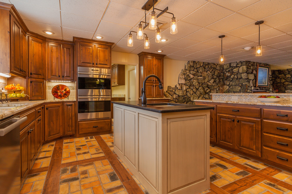 Foto på ett stort rustikt kök, med en dubbel diskho, luckor med upphöjd panel, skåp i mellenmörkt trä, granitbänkskiva, beige stänkskydd, stänkskydd i keramik, rostfria vitvaror, tegelgolv och flera köksöar