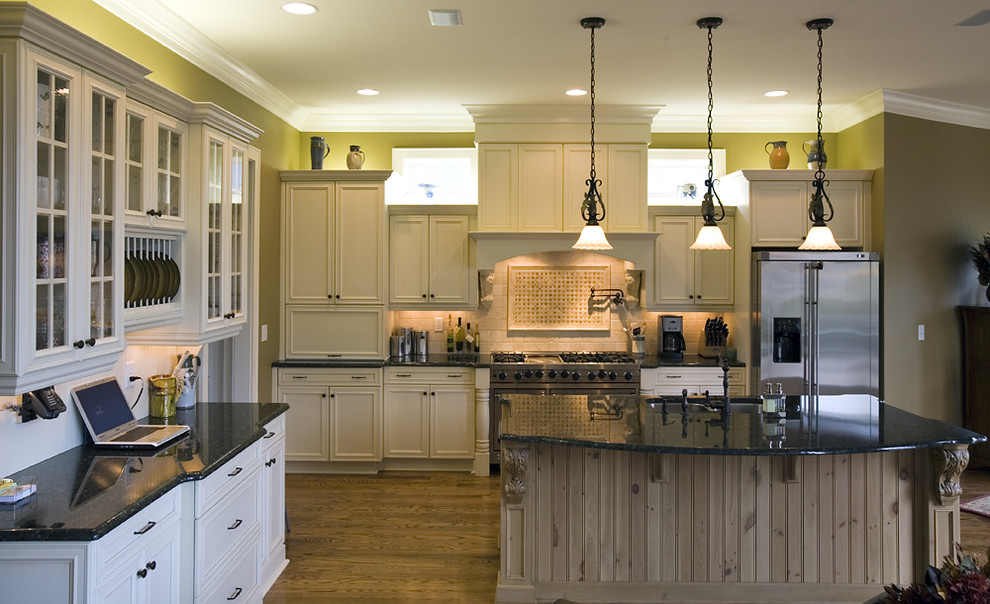 This is an example of a rustic galley kitchen in Charlotte with recessed-panel cabinets, stainless steel appliances, a submerged sink, beige cabinets and beige splashback.