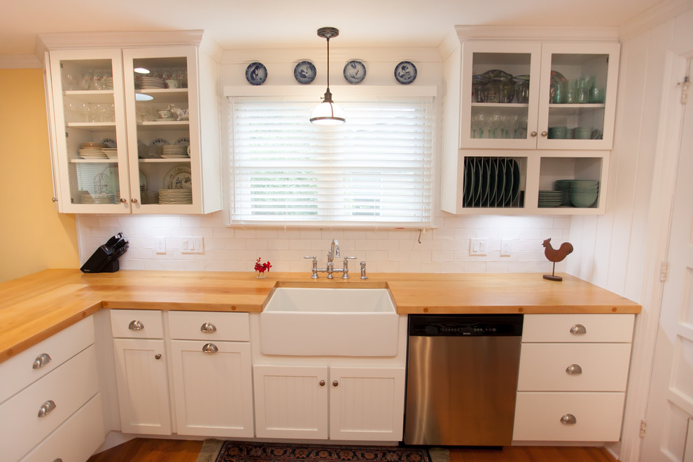 Foto på ett mellanstort rustikt kök, med en rustik diskho, vita skåp, träbänkskiva, vitt stänkskydd, rostfria vitvaror, mellanmörkt trägolv och en halv köksö