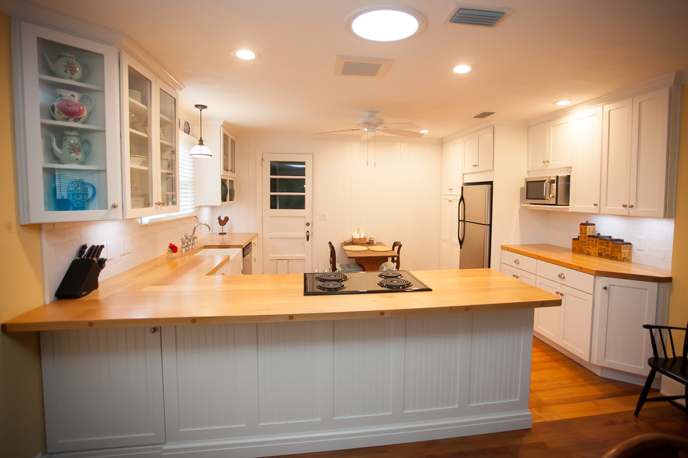 Mittelgroße Urige Wohnküche in L-Form mit Landhausspüle, weißen Schränken, Arbeitsplatte aus Holz, Küchenrückwand in Weiß, Küchengeräten aus Edelstahl, braunem Holzboden und Halbinsel in Jacksonville