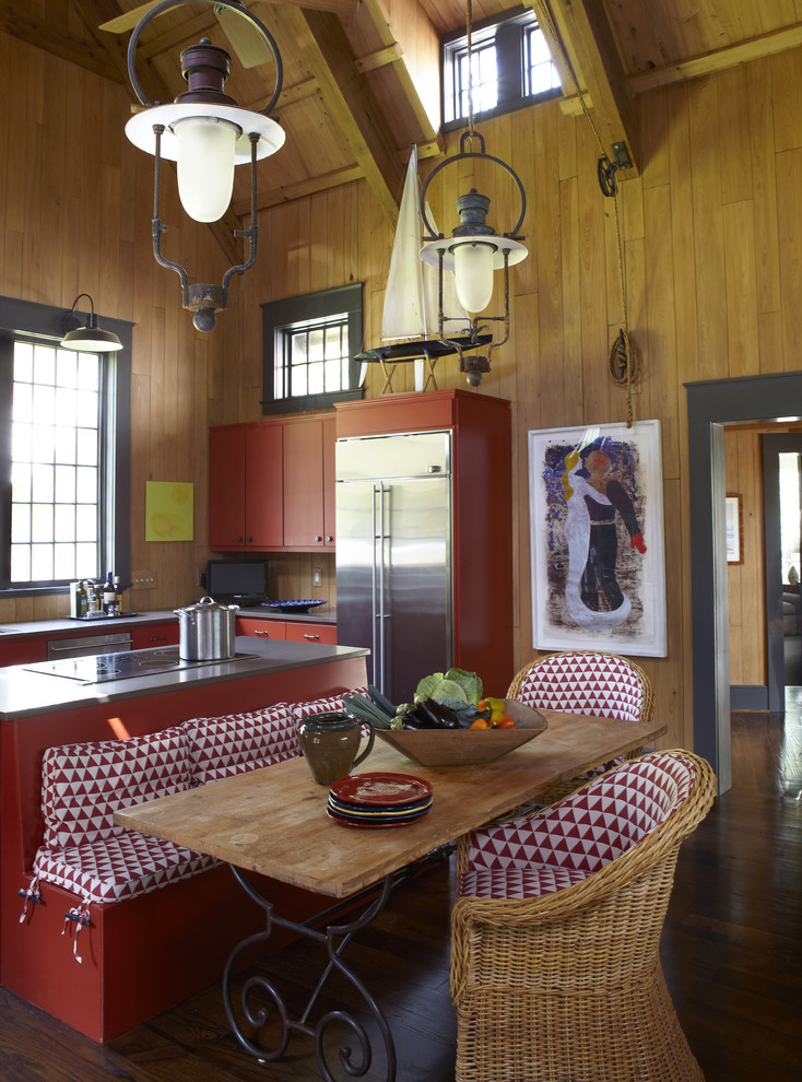 Rustik inredning av ett kök, med rostfria vitvaror och röda skåp
