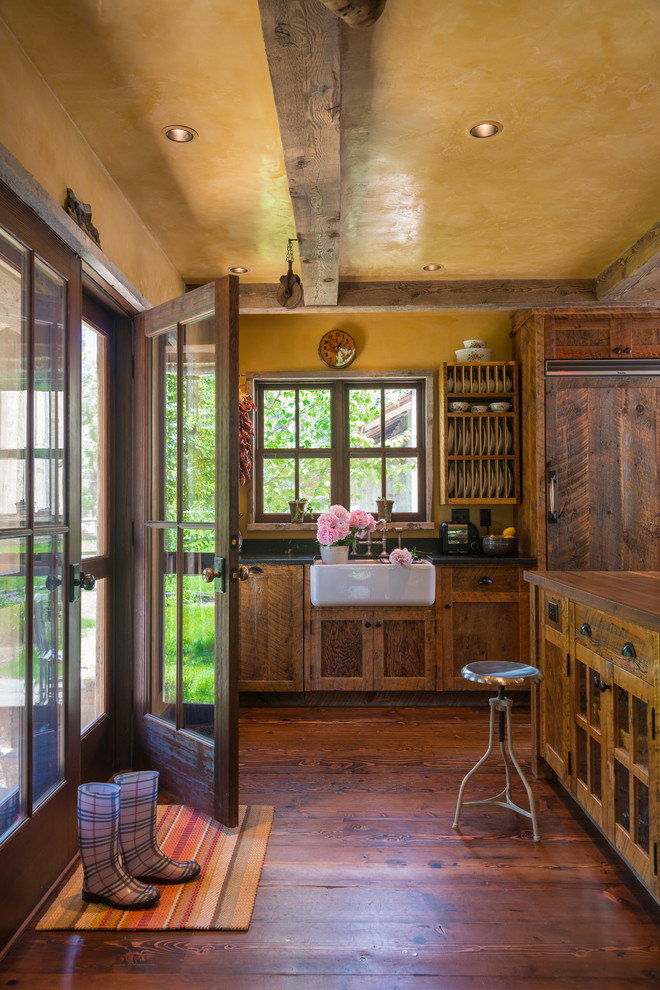 他の地域にあるラスティックスタイルのおしゃれなアイランドキッチン (シェーカースタイル扉のキャビネット、濃色木目調キャビネット) の写真