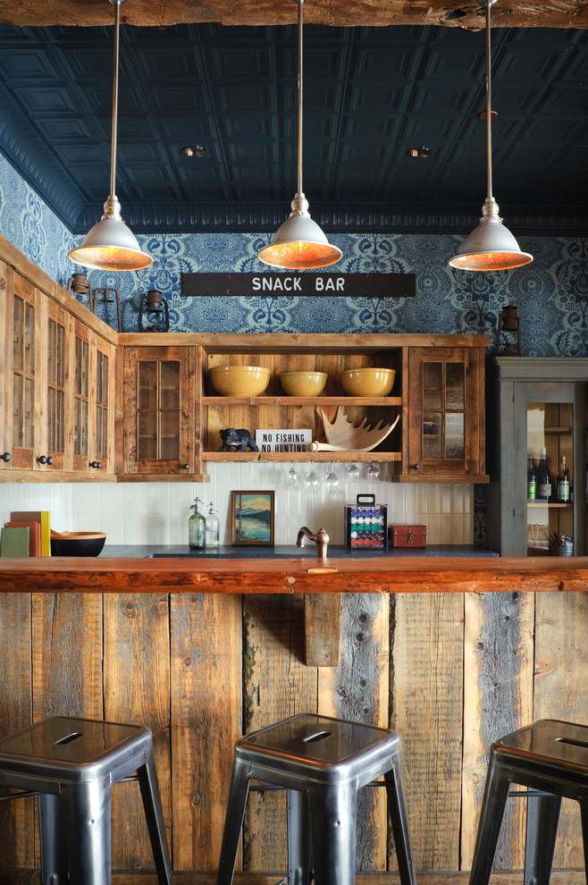 На фото: кухня в стиле рустика с деревянной столешницей и обоями на стенах с