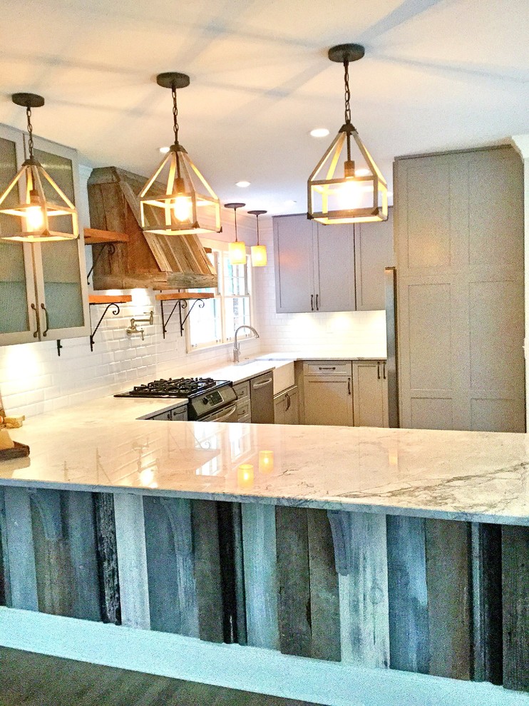 Example of a mid-sized mountain style u-shaped light wood floor open concept kitchen design in Atlanta with a farmhouse sink, shaker cabinets, gray cabinets, quartzite countertops, white backsplash, subway tile backsplash, stainless steel appliances and a peninsula