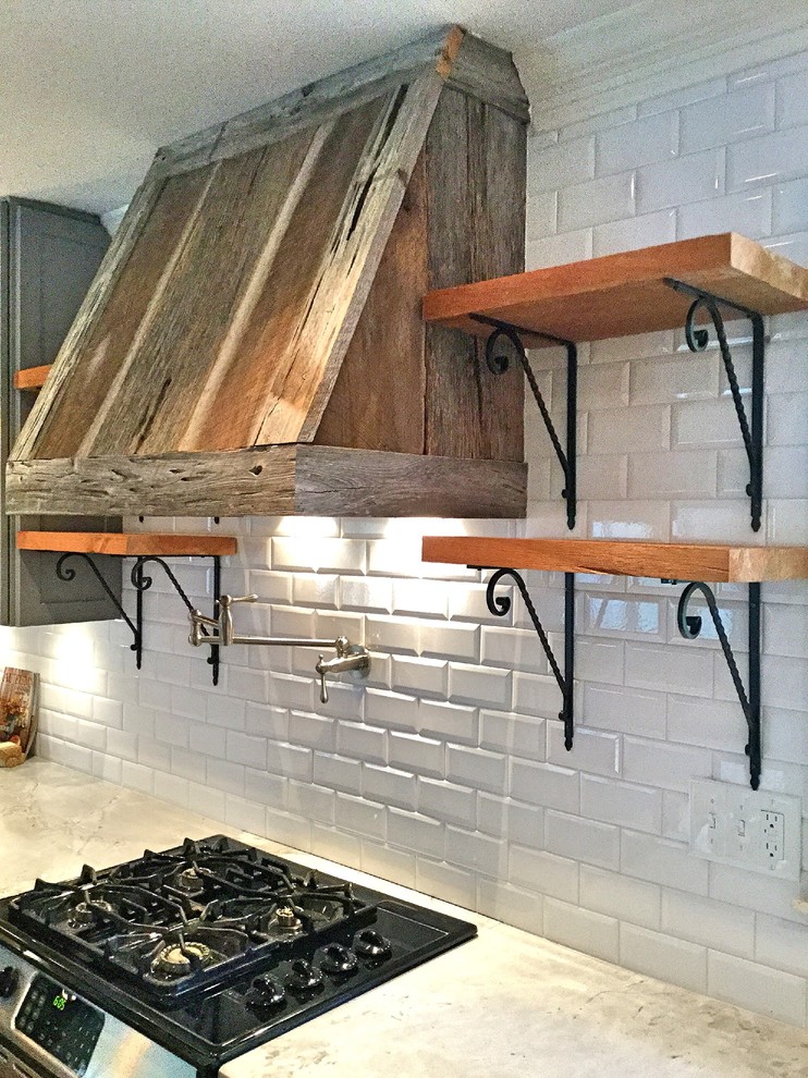Exempel på ett mellanstort rustikt kök, med en rustik diskho, skåp i shakerstil, grå skåp, bänkskiva i kvartsit, vitt stänkskydd, stänkskydd i tunnelbanekakel, rostfria vitvaror, ljust trägolv och en halv köksö