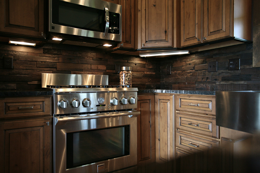 Inspiration för ett mellanstort rustikt kök, med en rustik diskho, luckor med upphöjd panel, skåp i mellenmörkt trä, granitbänkskiva, brunt stänkskydd, stänkskydd i trä, rostfria vitvaror, mörkt trägolv, en köksö och brunt golv