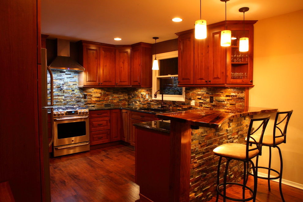 Example of a small mountain style u-shaped eat-in kitchen design in Other with a single-bowl sink, raised-panel cabinets, medium tone wood cabinets, granite countertops, multicolored backsplash, stone slab backsplash, stainless steel appliances and no island