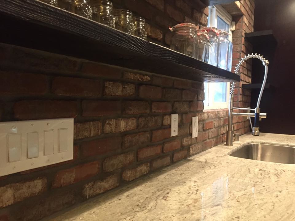 Foto di una grande cucina rustica con lavello sottopiano, ante in stile shaker, ante in legno bruno, top in granito, paraspruzzi marrone, paraspruzzi in mattoni, elettrodomestici in acciaio inossidabile, parquet chiaro e pavimento grigio