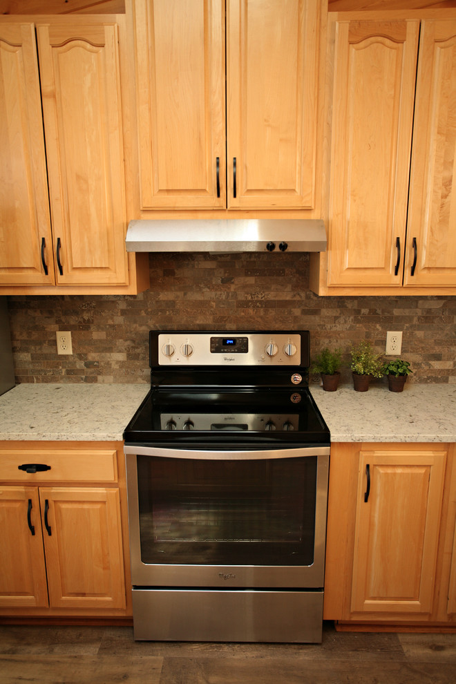 Bild på ett mellanstort rustikt kök, med en dubbel diskho, luckor med upphöjd panel, skåp i ljust trä, bänkskiva i kvarts, grått stänkskydd, stänkskydd i stenkakel, rostfria vitvaror, mellanmörkt trägolv, en köksö och brunt golv