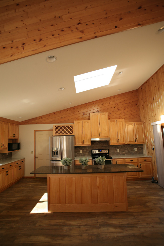 Foto på ett mellanstort rustikt kök, med en dubbel diskho, luckor med upphöjd panel, skåp i ljust trä, bänkskiva i kvarts, grått stänkskydd, stänkskydd i stenkakel, rostfria vitvaror, mellanmörkt trägolv, en köksö och brunt golv
