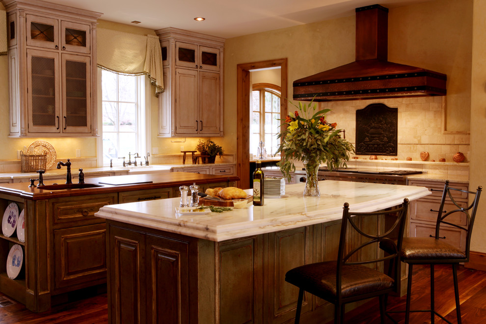 Foto på ett mellanstort rustikt kök, med marmorbänkskiva, en rustik diskho, luckor med upphöjd panel, skåp i slitet trä, beige stänkskydd, stänkskydd i stenkakel, integrerade vitvaror och mellanmörkt trägolv